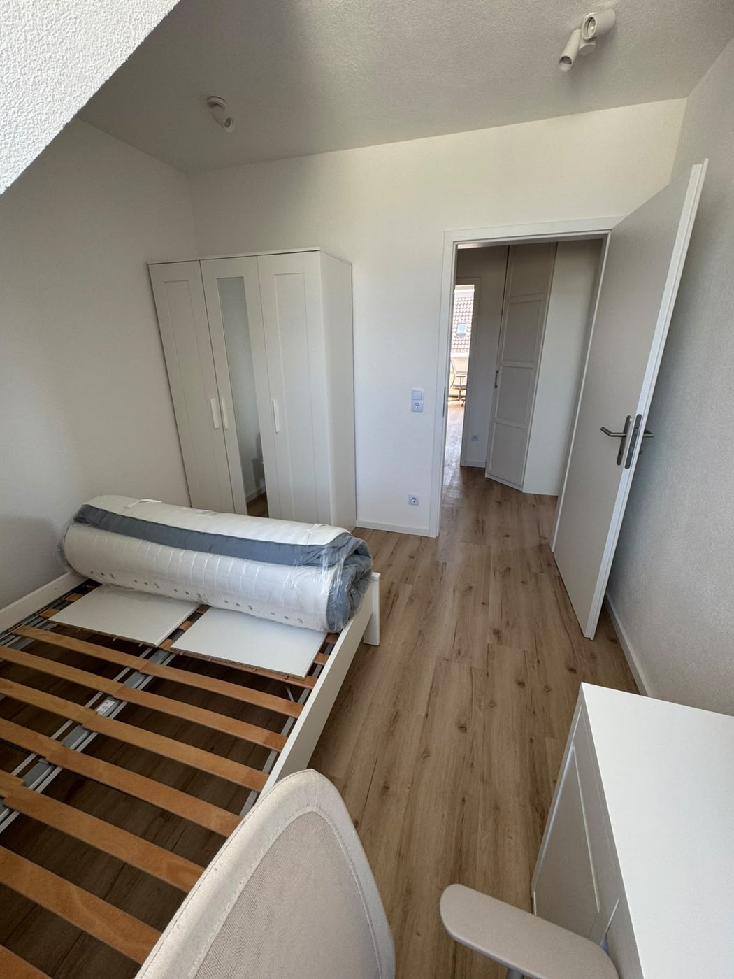 Zimmer mit Bett und Kleiderschrank